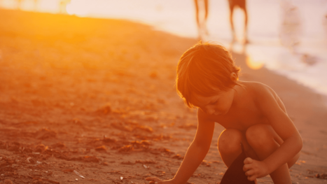 Kind spielt am Strand im Sand.