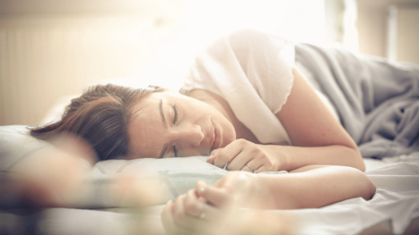 Frau schläft im Bett.