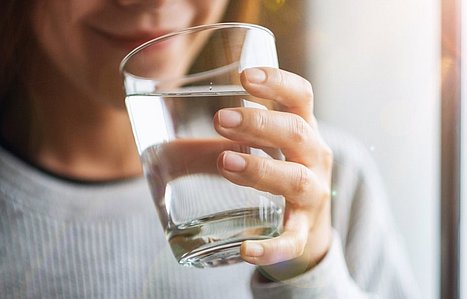 Frau trinkt ein Glas Wasser.