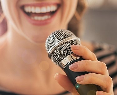 Frau singt in ein Mikrofon.