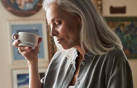 Eine Frau hält eine Tasse in der Hand.