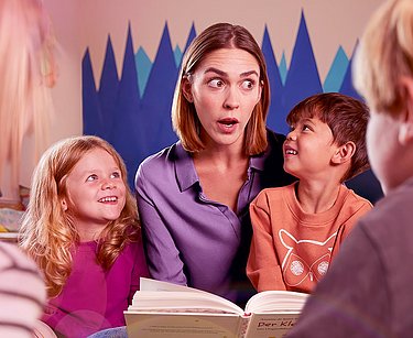 isla<sup>®</sup> med voice bei belastungsbedingten Stimmbeschwerden. Frau liest Kindern ein Buch vor.