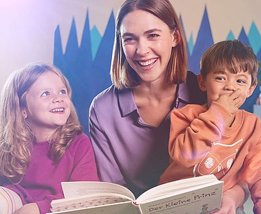 Erzieherin liest Kindern ein Buch vor
