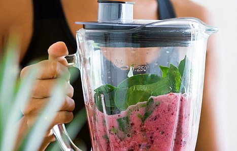 Frau hält Mixer mit gesundem Smoothie in Händen